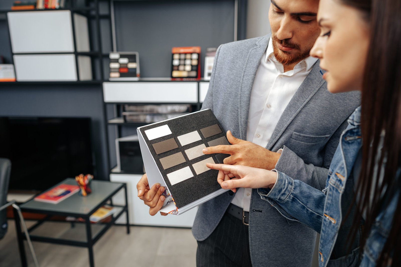 salesman shows color swatches to lady customer for new kitchen furniture